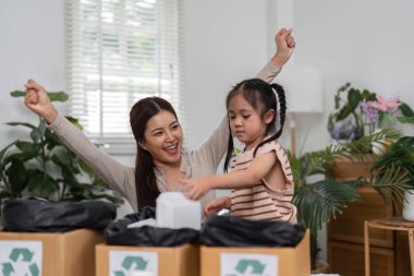 Başarılı bir sınıflandırma seansından sonra, bir anne kızına geri dönüşümle ilgili heyecanı paylaşır, elle öğrenme yoluyla çevreye bakmanın önemini güçlendirir..