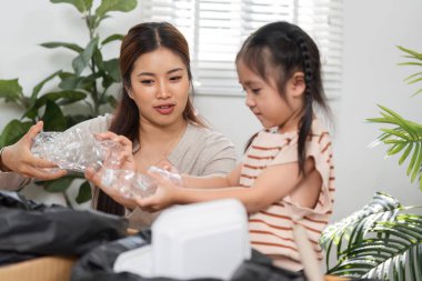 Bu sahne, nesneleri sınıflandırmak için birlikte çalışırken, ekolojik bilinçli yaşamın ve aile işbirliğinin önemini vurgulayan ihale bağını yakalıyor..