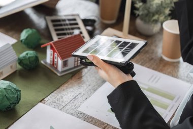 Profesyoneller güneş panelleri sunarken, çevre dostu evlerin modellerini inceleyerek enerji çözümlerindeki sürdürülebilir gelişimi vurguluyorlar.