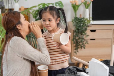 Anne ve kızı geri dönüşümleri ayırırken sürdürülebilir yaşam ve çevresel farkındalığı teşvik eden eğlenceli bir anın tadını çıkarıyorlar..