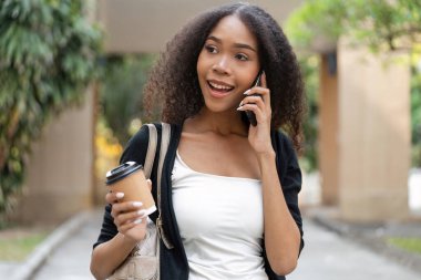 Bir kadın, sürdürülebilir kahve seçimiyle geliştirilmiş neşeli bir anı gösteren canlı bir telefon konuşmasından hoşlanır..