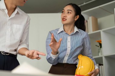 Profesyoneller mimari planlar ve tasarımda iletişimin önemini belirten bir model ev üzerinde strateji oluştururken, canlı bir tartışma ortaya çıkıyor..