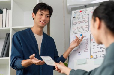 Bir tasarımcı UX tasarım kavramları, kablo gösterimi, zorluklar ve projeler için olası çözümler sunumu sırasında takım üyeleriyle bağlantı kurar.