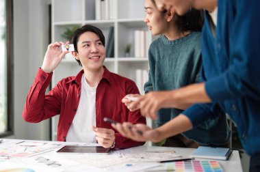 Bir tasarım oturumuna katılanlar kullanıcı arayüzü geliştirme kavramlarını gururla sunar, işbirliği ve geri bildirim üzerine odaklanırlar.