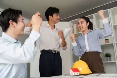 Takım, bir proje planını başarıyla tamamladıktan sonra takım çalışmasının tasarım alanındaki gücünü göstererek başarılarını kutluyor..