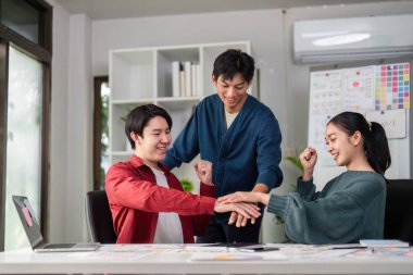 Parlak bir çalışma alanında, üç meslektaşı bir beyin fırtınası oturumuna hevesle katılarak, fikirlerini paylaşıyor ve UXUI proje geliştirme süresince işbirlikçi faaliyetlerden keyif alıyorlar..