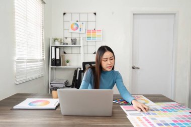 Tasarımcı, dijital görevler ve profesyonel bir ortamda uygulamalı renk keşfi arasında uyumlu bir denge oluşturarak çeşitli renk seçimleriyle meşgul olur..