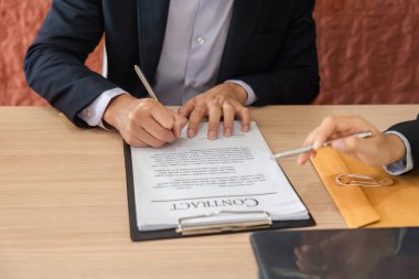 Resmi bir sözleşme imzalayan, işbirliği sergileyen ve iş anlaşmalarına güvenen iki profesyonel..