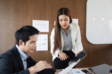 Modern bir ofisteki profesyoneller proje belgeleri üzerinde işbirliği yaparken, veri içgörülerini birlikte gözden geçirir, takım çalışmasını ve stratejik planlamayı teşvik ederler..