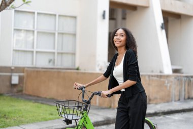 Bir kadın canlı yeşil bir bisiklete binmekten zevk alıyor, şehri keşfederken sürdürülebilir hareketliliği kucaklıyor..