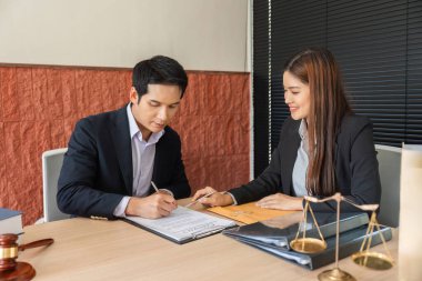 Sözleşmeli anlaşmanın tamamlanmak üzere olan iki kişi arasındaki odaklanmış bir konuşma, ayrıntıları birlikte yansıtıyor..