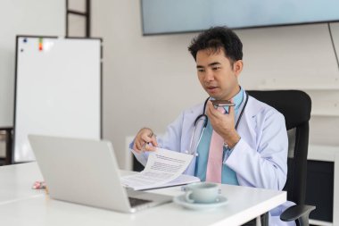 Doktor, tıbbi prosedürleri açıklayan ve evdeki hastalara dijital bir platform aracılığıyla kapsamlı destek sağlayan bir tele-sağlık oturumunu yönetiyor..