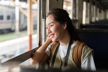 Neşeli bir gezgin, gezgin şehvetin özüyle çevrili yeni bir maceraya atılırken sevinç ve heyecanı ifade ederek, tren koltuğundan manzaranın tadını çıkarır..