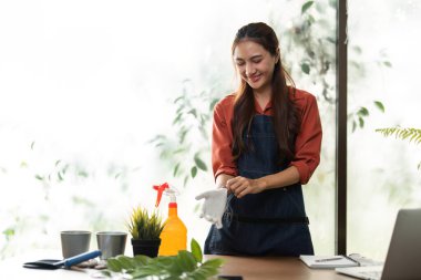 Bu mutlu bahçıvan bitkilerle vakit geçirmekten zevk alıyor, sürdürülebilir bahçıvanlık uygulamalarının ve doğayı yetiştirmenin getirdiği mutluluğu gösteriyor..