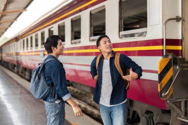 Tren yaklaşırken, iki arkadaş heyecanlarını paylaşıyor ve bavullarını kontrol ediyor, birlikte yeni bir yolculuğa çıkmaya hazırlanıyorlar..