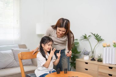 Bir anne ve kızı anlamlı bir anı paylaşır. Anne, çocuklarını öğrenmesi için cesaretlendirirken oyun stratejilerini de açıklar..