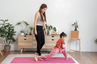 Destekleyici bir atmosferde, bir anne kızını hamleler yapmaya teşvik eder, fitness ve sağlıklı alışkanlıklar için sevgiyi teşvik eder..