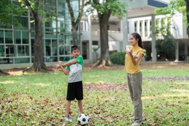 Bir kız ve bir erkek ısınmak için esneme egzersizleri yaparlar, doğanın tadını çıkarırken spor ve sağlığı teşvik ederler..