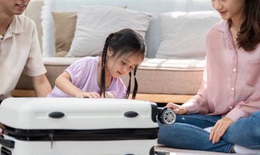 Bir aile, yaklaşan bir yolculuğa hazırlanmak için evde toplanıyor. Küçük bir kız heyecanlı bir şekilde bavulu inceliyor. Bağlantı ve macera anlarını yansıtıyor..