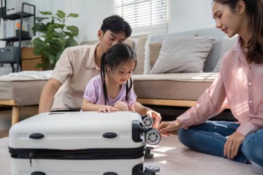 Oyuncu bir kız, ailesi ona yardım ederken bir bavulla etkileşime girer. Rahat bir yuva ortamında aile hayatının neşesini ön plana çıkarır..