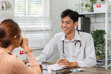Bir doktor hastasıyla dostça bir konuşma yapar, sağlık sorunlarını tartışır ve klinik ortamında kişisel bakım sağlar..
