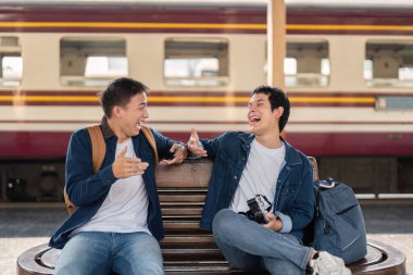 İki arkadaş tren istasyonundaki yolculuklarına devam ediyor, hikayelerini ve kahkahalarını paylaşıyorlar. Gerçek bağlantıları, birlikte seyahat etmenin hazzını yansıtıyor..