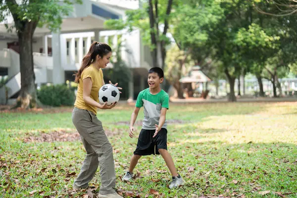 Çocuklar bir futbol oyununa dalmış, oyun yoluyla sosyal becerilerini geliştirirken, açık hava aktivitelerine olan heveslerini ve enerjilerini sergiliyorlar..