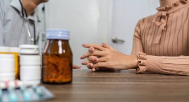 Bir doktor ve hasta, birlikte ilaç ve tedavi seçeneklerini tartışarak, hastaların sağlığı hakkında detaylı bir konuşma yapar..