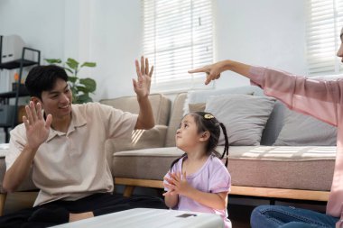 Bir anne ve baba, eğlenceli jestler kullanarak kızlarını oyun zamanı boyunca cesaretlendirir ve yaklaşan seyahatlerini kutlarken onlarla bağlantı kurarlar..
