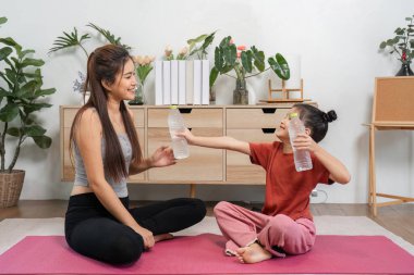 Bu etkileşim, bir anne ve kız olarak, birbirlerine yakın ilişkilerini güçlendirerek, su şişelerini değiş tokuş ederek yoga uygulamalarını kutlamanın mutluluğunu vurguluyor..