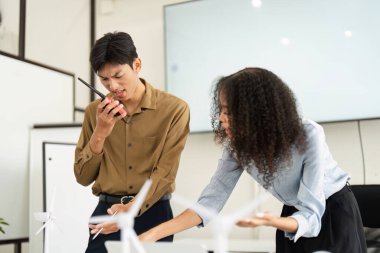 Yenilenebilir enerji projelerindeki engelleri ele alan iki ekip üyesi, profesyonel bir ortamda yenilikçi çözümlere olan bağlılıklarını sergiliyorlar..
