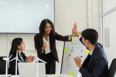 Takım üyeleri olarak başarılı ESG girişimleri, somutlaştırıcı takım çalışması ve sürdürülebilirliğe olan bağlılıkları için beşlik çakma anı.