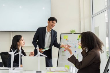 Bir grup meslektaşı, modern ofis ortamında takım çalışması ve sürdürülebilirliği vurgulayan yenilikçi ESG stratejileri üzerinde kafa patlatıyor..