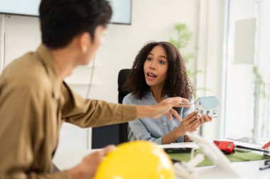 Yaratıcılığı ve yeniliği teşvik eden tasarım modelleriyle çevrili sürdürülebilir mimari hakkında canlı bir tartışmada profesyoneller.