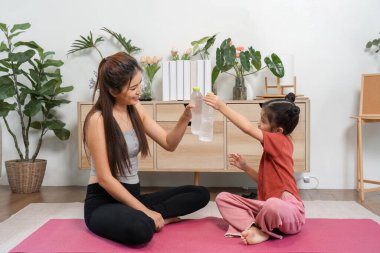 Canlı bir atmosferde, bir anne ve kız, bir su şişesi değiş tokuşunda, kahkahalarla dolu aktif bir yaşam tarzını somutlaştırarak, suyu eğlenceli hale getirirler..
