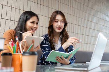 İki öğrenci bir kafede birlikte okurken sezgilerini paylaşıyorlar. Notlarını ve dijital kaynaklarını incelerken kavramları tartışmayı seviyorlar..