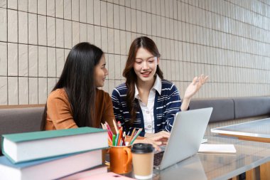 İki öğrenci bir proje üzerinde birlikte çalışıyorlar, parlak ve modern bir çalışma alanında fikir ve anlayış paylaşıyorlar. Müdahaleleri takım çalışması ve akademik desteği vurguluyor.