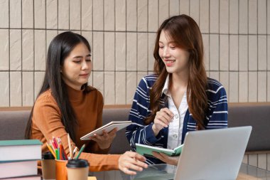 İki öğrenci verimli bir eğitim materyali ve anlayış alışverişinde bulunarak, içkilerinin keyfini çıkarırken işbirlikçi bir akademik ortamı teşvik ediyorlar..
