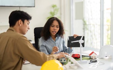 Profesyoneller rüzgar türbinlerinin modellerini kullanarak, yaratıcı ve işbirlikçi bir atmosferi teşvik ederek çevre dostu enerji stratejileri hakkında görüşlerini paylaşıyorlar..