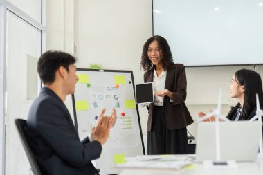 Enerjik bir toplantıda, ekip üyeleri ESG stratejilerinin başarısını alkışlayarak sürdürülebilirliğe olan bağlılıklarını gösterdiler..