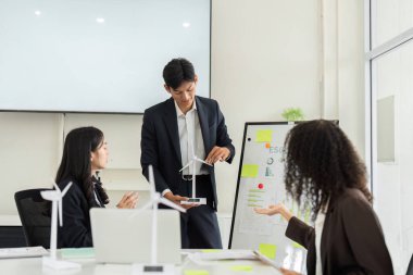 Dinamik bir sunum sırasında, bir ekip üyesi yenilenebilir bir enerji modeli sergileyerek, meslektaşları arasında çevre dostu uygulamalara ilgi uyandırdı.