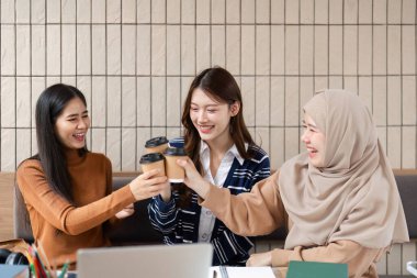 Çalışma seanslarının ortasında, üç arkadaş gelişmelerini neşeli bir kadeh kaldırmayla kutluyorlar, dostluk ve eğlence ruhunu somutlaştırıyorlar..