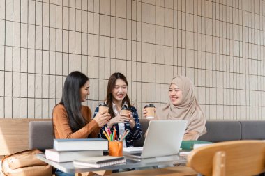 Üç arkadaş kahve içerken keyifli bir anı paylaşıyor. Çalışmaları hakkında coşkulu tartışmalar yapıyorlar. Birlikte öğrenmenin sevincini gösteriyorlar..
