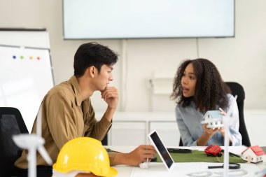 Sürdürülebilir tasarımlar ve stratejileri analiz eden profesyoneller arasında canlı bir tartışma ortaya çıkıyor ve mimari modeller çalışma alanlarında belirgin bir şekilde sergileniyor.