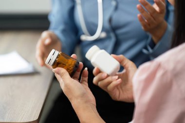 Sağlık hizmetlerini besleyen bir ortamda, bir hemşire, hastanın tedavileri hakkında iyi bilgilendirilmesini sağlamak için ilaçlarla ilgili hayati bilgileri iletir..