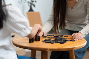 Bir anne kızına domino taşında yardım eder. Yaratıcılığı ve öğrenmeyi teşvik eden eğlenceli ama eğitici bir ortam yaratır..