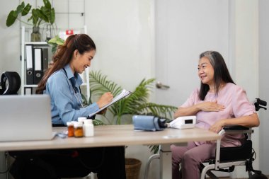 Huzurlu bir klinikte, bir hemşire sağlık durumuyla ilgili notlar alır ve sağlık kontrolü sırasında rahat ve iyi olduğundan emin olur..