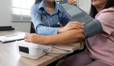 Uzman bir hemşire yaşlı bir hastanın tansiyonunu ustalıkla ölçer ve muayene sırasında doğru ölçümler ve destek sağlar..