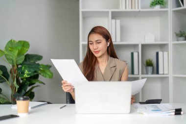 Bir video görüşmesinde, bir kadın etkili iletişimin önemini vurgulayarak doğruluğu ve netliği sağlamak için belgelerini gözden geçirir..