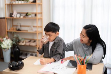 Bir anne, oğlunun okul için hazırlanmasına yardım eder. Birlikte geçirdikleri zamanın tadını çıkarırken, oğlunun ihtiyacı olan her şeye sahip olmasını sağlar. Görüntü, aile desteği ve eğitiminin özünü yansıtıyor..